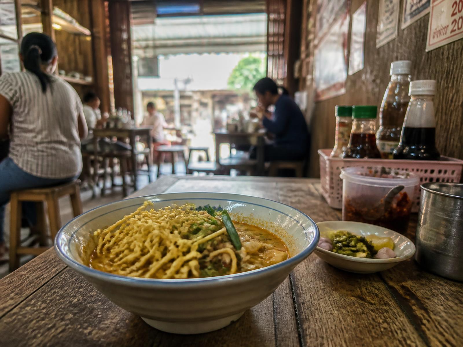 A bowl of khao soi in a small local Chiang Mai noodle shop